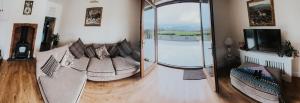 a living room with a couch and a large mirror at Dunard house. in Tullaha