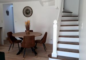 een eetkamer met een tafel en stoelen en een trap bij Les Chaumines, St Cast le Guildo in Saint-Cast-le-Guildo +16 foto's