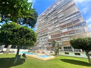a tall building with a pool in front of it at Albatros 13º in Benidorm
