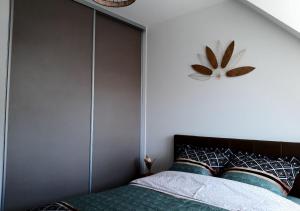 een slaapkamer met een bed en een klok aan de muur bij Les Chaumines, St Cast le Guildo in Saint-Cast-le-Guildo