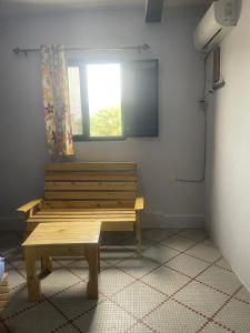 a wooden bench in a room with a window at Auberge-Café-Restaurant TUNIS in Nouakchott