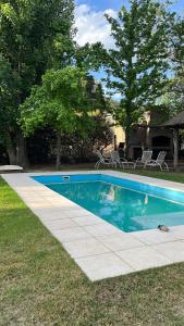 a swimming pool in a yard with chairs and trees at El Cortijo del Chorrillo in San Luis