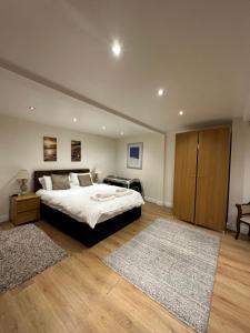 a bedroom with a large bed and a wooden cabinet at The Carlton's Holiday Suites in Bridlington