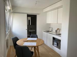 een keuken met een tafel en stoelen in een kamer bij Studio proche de la gare ! in Lausanne