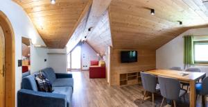 Camera con soffitto in legno, tavolo e sedie. di Berghotel Schlemmer a Bressanone