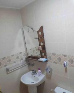 ein Bad mit einem Waschbecken und einem Wandspiegel in der Unterkunft Appartement Wynwood 3 in Oujda