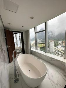 uma casa de banho com uma grande banheira branca em frente a uma janela em Hotel Nacional Rio de Janeiro no Rio de Janeiro