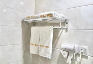a towel rack with towels and a hair dryer in a bathroom at Sao Mai Hotel in Ho Chi Minh City