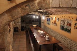 einen langen Tisch in einem Zimmer mit einer Steinmauer in der Unterkunft Cal Marques in Santa Oliva