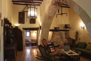 a living room with a stone archway and a table and chairs at Cal Forner in Santa Oliva