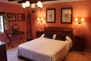 a bedroom with a bed in a room with orange walls at Cal Forner in Santa Oliva