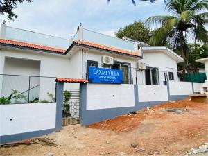 a house with a blue sign in front of it at Laxmi Villa 3BHK Premium Villa with terrace Anjuna in Anjuna