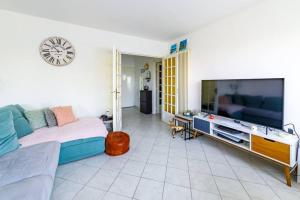 a living room with a large flat screen tv at Pointe Rouge à 2mn de la plage - avec petite vue mer in Marseille