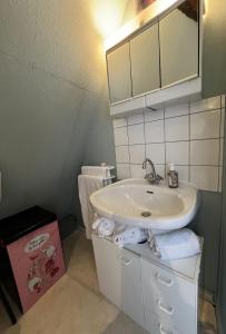 a bathroom with a sink and a mirror and towels at Gîte Trotthus maison familiale avec piscine in Hunawihr