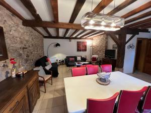 salon z białym stołem i czerwonymi krzesłami w obiekcie Gîte Trotthus maison familiale avec piscine w mieście Hunawihr