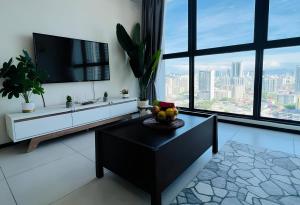 a living room with a television and a table with fruit on it at Urban Suites by PerfectSweetHome Cozy Style in Jelutong