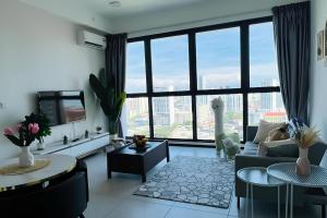 a living room with a couch and a large window at Urban Suites by PerfectSweetHome Cozy Style in Jelutong