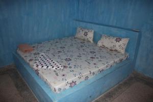 a blue bedroom with a bed with a blue wall at Mbuyuni Lodge Nungwi in Nungwi