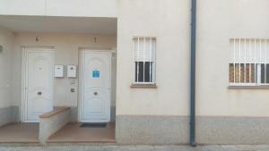 two white doors on the side of a building at Casa el Sol in Lumpiaque