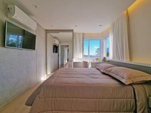 a bedroom with a large bed with a large window at Residencial Toscano 2 Suítes by Achei Gramado in Gramado