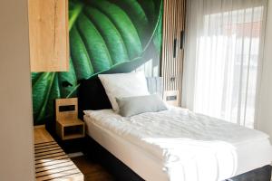 a bedroom with a bed with a green wall at Boardinghouse Hense in Lingen