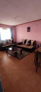 a living room with couches and a table and a window at Airbnb in Mwea town 