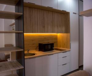a kitchen with a sink and a microwave at Yellow Studio Retreat Tivat in Tivat +8 photos
