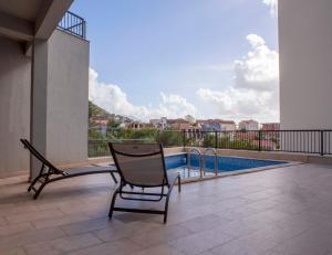 a patio with a chair and a swimming pool at Yellow Studio Retreat Tivat in Tivat