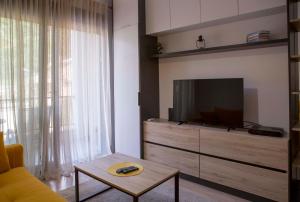 a living room with a couch and a tv at Yellow Studio Retreat Tivat in Tivat