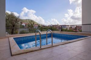 a swimming pool with two metal rails next to a building at Yellow Studio Retreat Tivat in Tivat
