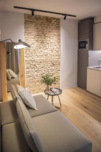 salon z kanapą i ceglaną ścianą w obiekcie RICCIONE SUITE DESIGN w mieście Riccione