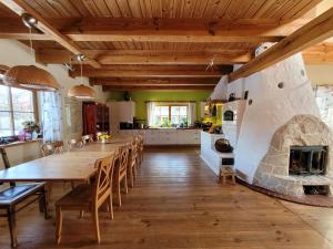 uma grande cozinha com uma mesa longa e uma lareira de pedra em Siedlisko Chatka Zagajdzie 