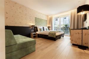 una camera con letto e divano di Cityhotel Goldener Adler B&B a Chiusa