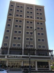 a tall building with a sign on the front of it at Hotel Hilen De Ville in Erbil