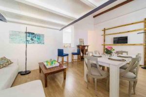 a dining room with a white table and chairs at Archimede Suite Apartment - Morici Street in Palermo