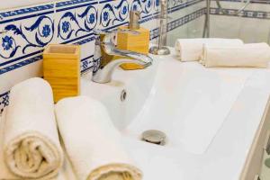 a bathroom sink with a faucet and some towels at Archimede Suite Apartment - Morici Street in Palermo