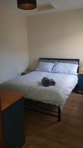 ein Bett mit einem schwarzen Kopfteil und zwei Kissen in der Unterkunft Beautiful Apartment in the city center in Belfast