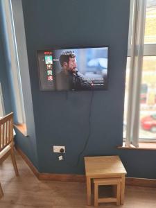 a flat screen tv on a blue wall at Beautiful Apartment in the city center in Belfast +8 photos