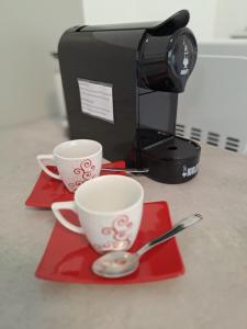 フェラーラにあるGiulio D'Esteのコーヒーメーカーの横にある赤いトレイのカップ2杯