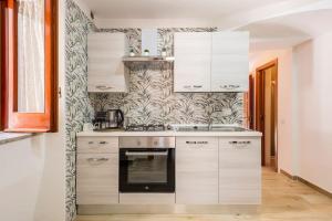 a kitchen with white cabinets and a stove at Love House sul mare in Cetara