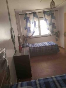 ein Schlafzimmer mit einem Bett und einem Fenster in einem Zimmer in der Unterkunft Appartement Wynwood 2 in Oujda
