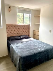 Un dormitorio con una cama grande y una ventana en Apartamento Toledo Campestre, en Bello