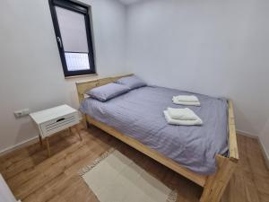 a bedroom with a bed with two towels on it at La Casuță in Dej