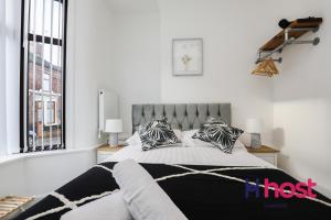 a bedroom with a bed with black and white pillows at Host Liverpool - Gorgeous Anfield home in Liverpool