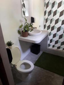 a bathroom with a toilet and a sink at Backpackers Hostel in Sipacate