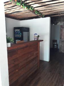 a room with a wooden counter with a tv on it at Backpackers Hostel in Sipacate