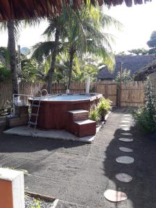 a hot tub in a backyard with a palm tree at Backpackers Hostel in Sipacate