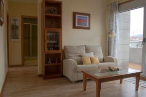 a living room with a couch and a coffee table at Apartamento Punta Balea in Cangas de Morrazo
