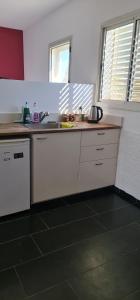 a kitchen with white cabinets and a counter top at Studio at the Kibbutz in Ashdot Ya‘aqov