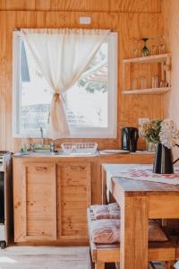 cocina con fregadero y ventana en CABAÑAS TRAPEN, en Puerto Montt